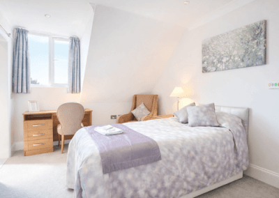 Light and airy bedroom with double bed, desk, armchair and large window allowing natural light.