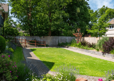 Outdoor garden area with pergola seating, landscaped borders and accessible paved paths for residents.