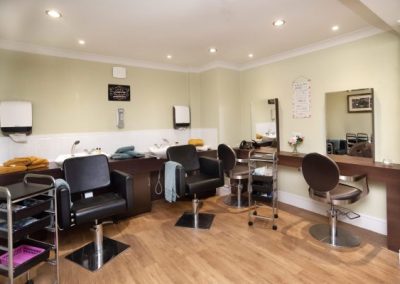 Fully equipped in-house salon with styling chairs, mirrors and washing stations for resident pampering.