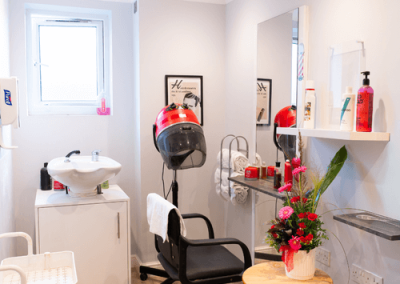 Dedicated in-house hair salon with styling chair, hair dryer and welcoming décor for resident pampering.
