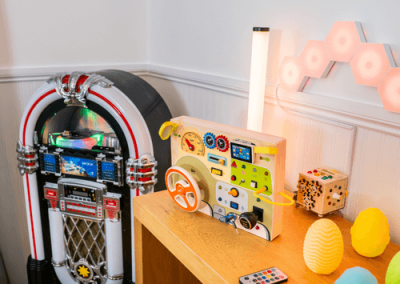 Sensory space featuring a retro-style jukebox, interactive activity board and soft lighting for resident engagement.